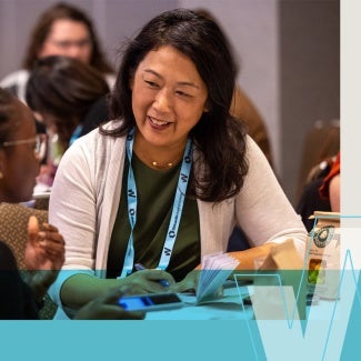 Diverse women interacting and learning at Women's Leadership Summit.
